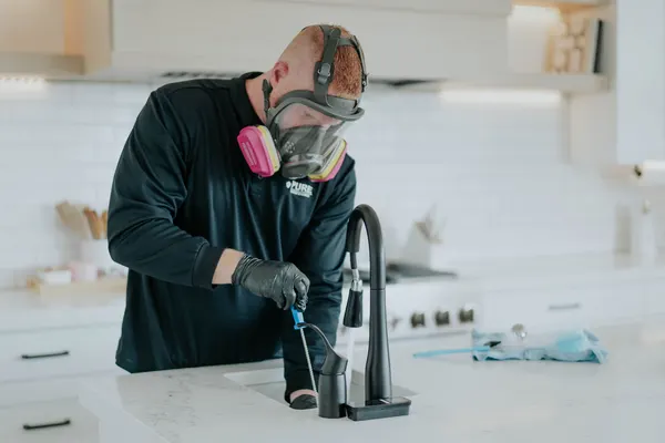 Technician testing water source with respirator